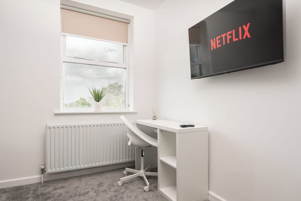 Main bedroom with a zip-and-link bed that can be arranged as a superking or two singles. Includes a private ensuite, in-room sink, desk and chair, clothes rail, and Smart TV. Please let us know your bedding preference prior to your stay.