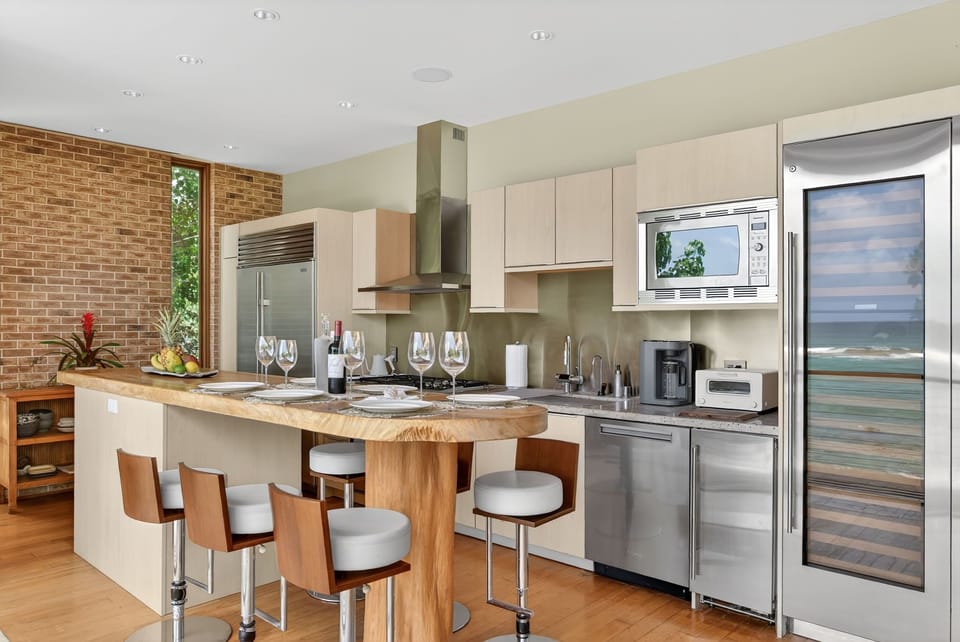 The chef-ready kitchen features premium appliances, custom cabinetry, granite countertops, and generous seating for gathering together.