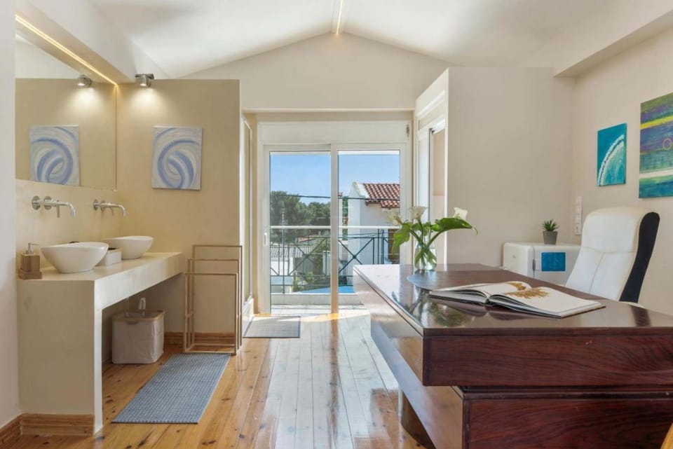 A bright bedroom featuring a dedicated workspace beside the window, creating a comfortable setting for catching up on emails, remote work or planning the day's activities.