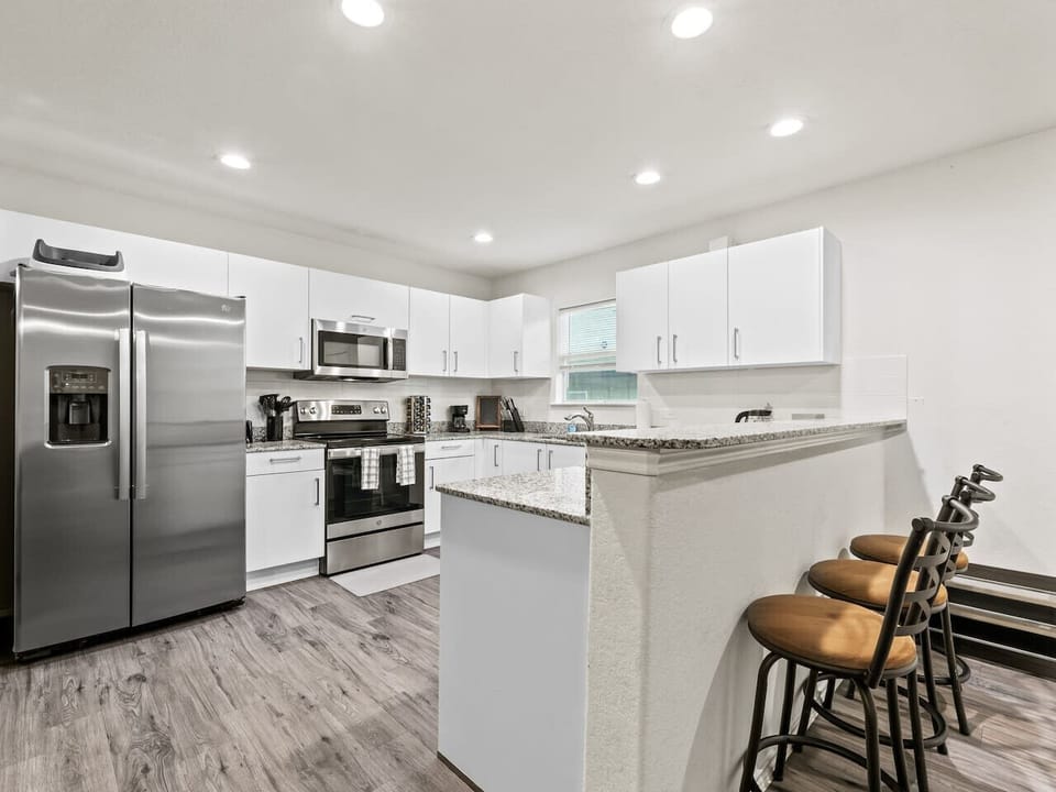 A fully equipped modern kitchen featuring stainless steel appliances, ample counter space, and all the essentials you need to cook meals during your stay. Designed for convenience and functionality.