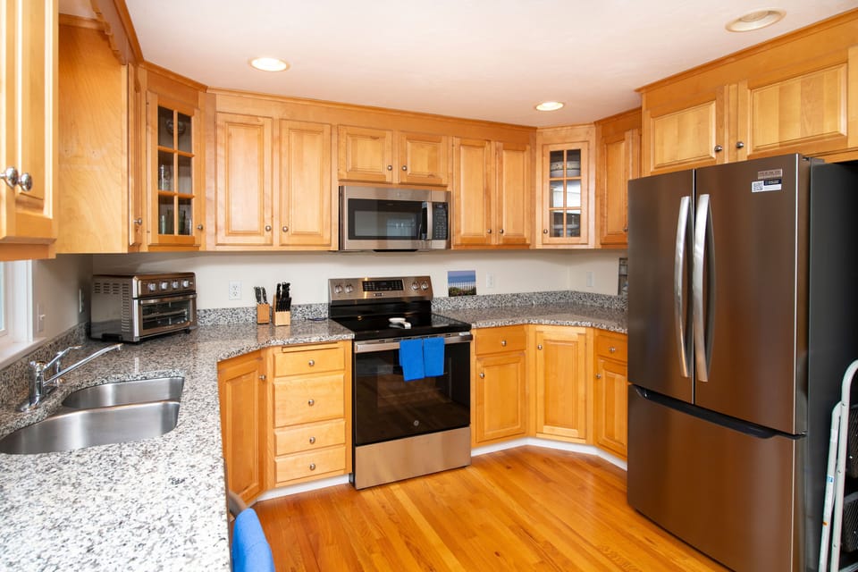Craft delicious meals in this bright kitchen, featuring maple cabinets and sleek granite countertops.