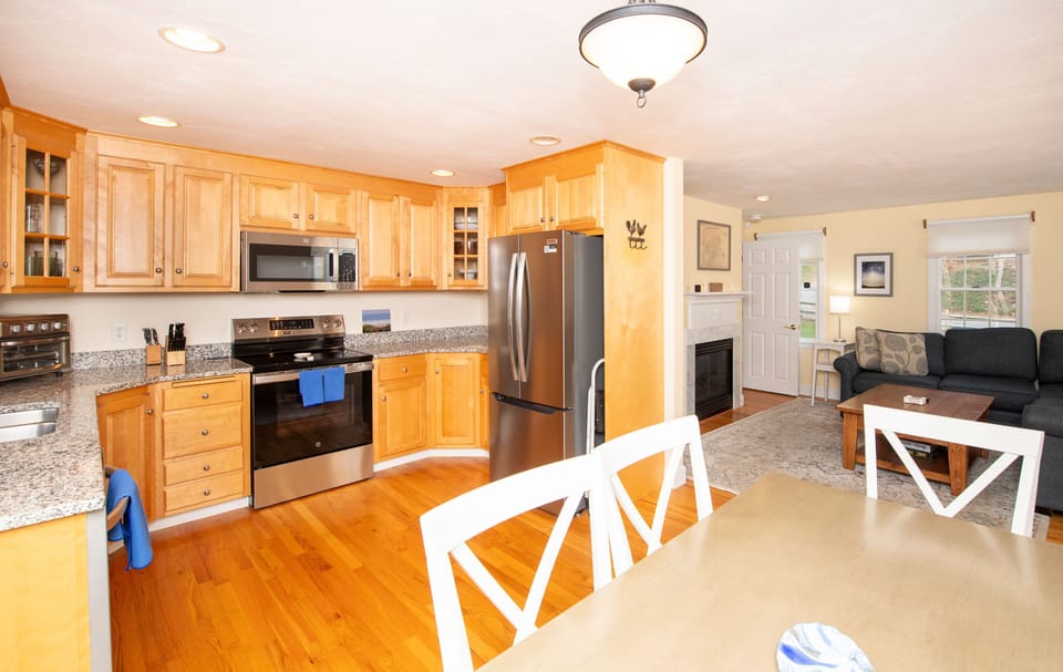Enjoy family meals at the dining table with a cozy view of the living space, perfect for gathering.