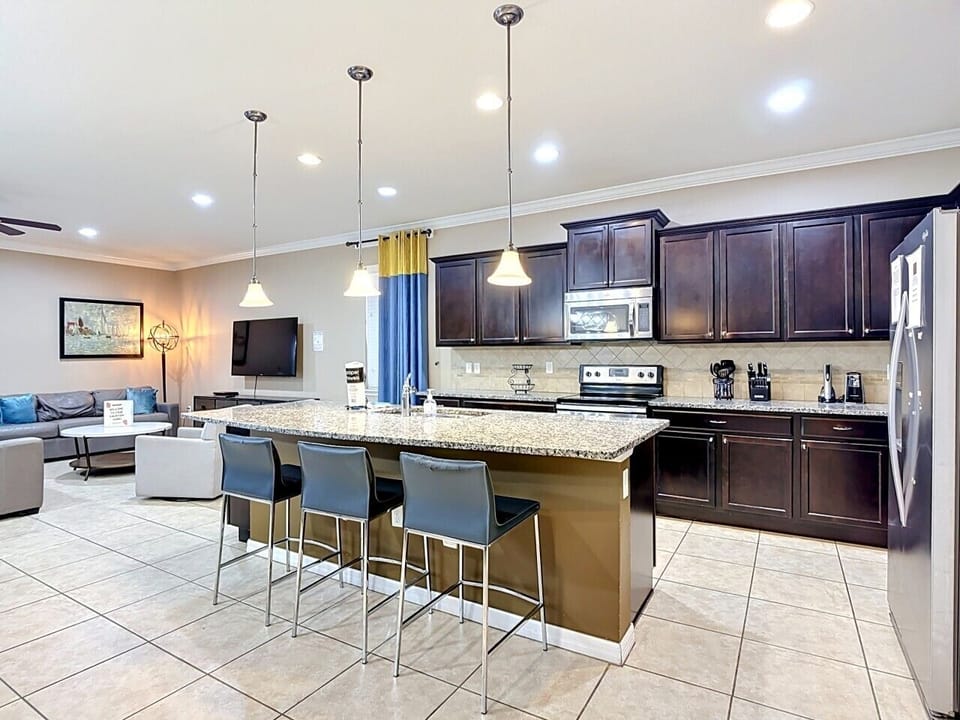 Modern chef’s kitchen with oversized granite island, bar seating, and plenty of space for entertaining.