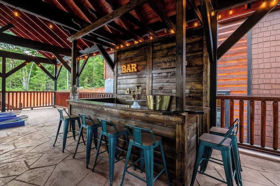 Rustic covered outdoor bar with string lights and cozy deck seating