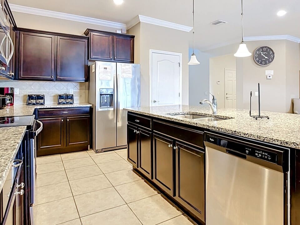 Bright gourmet kitchen with expansive granite countertops, center island, and open-concept design.