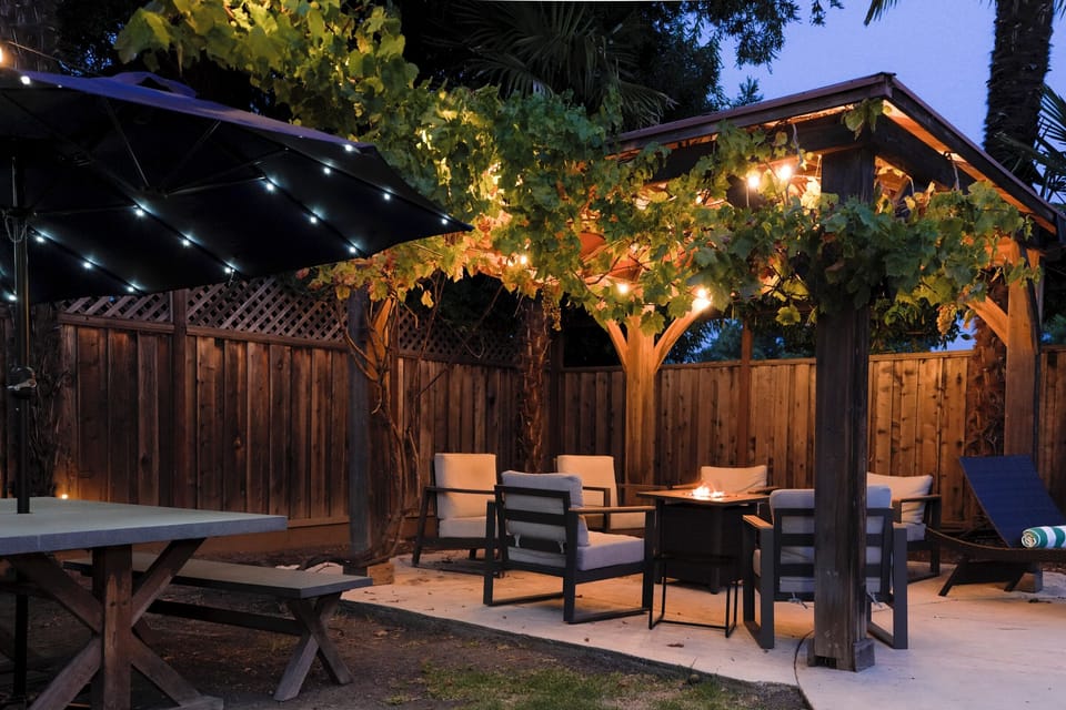 Charming private patio with pergola, fire pit, and cozy evening lighting