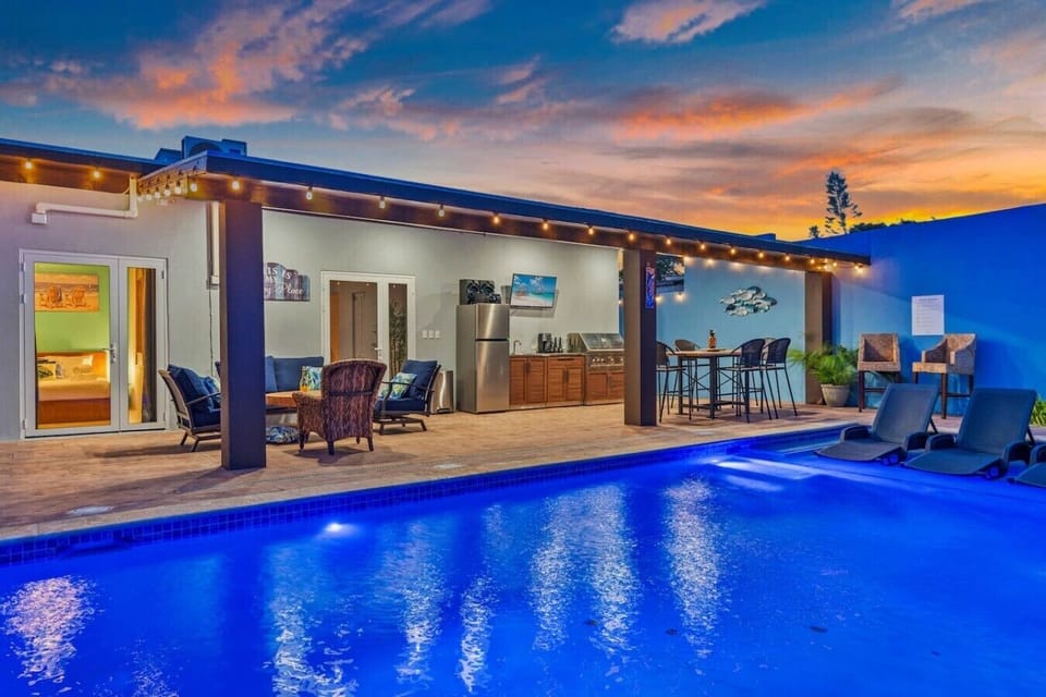 Sip a cold drink and lounge under the sun by the sparkling pool, where tropical vibes and a relaxing setup create the perfect spot for easy island downtime.