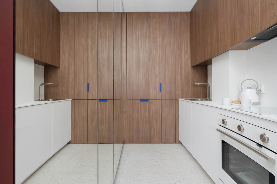 Contemporary kitchenette featuring built-in appliances, generous storage, and functional workspace.
