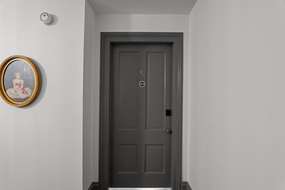 Door to unit, punch in personalized code into smart lock for entry 