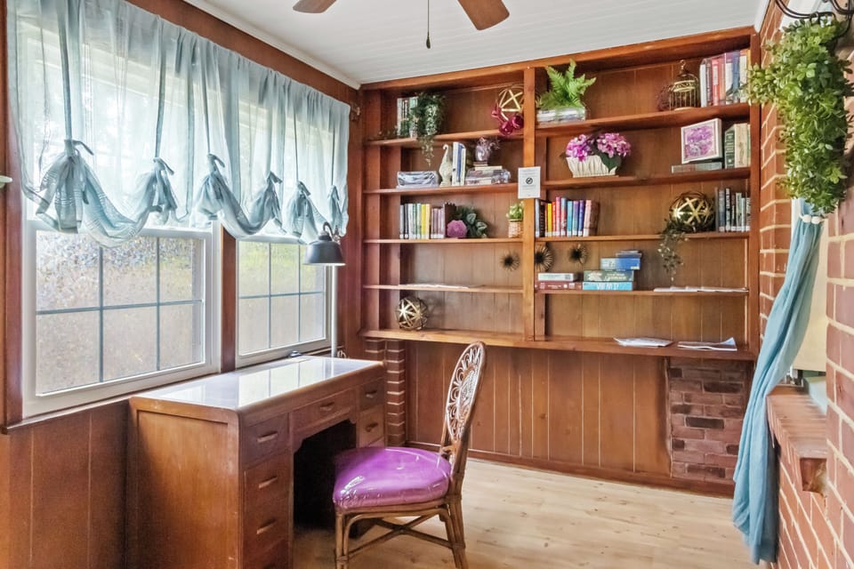 Charming workspace with natural light and built-in shelves—perfect for reading or remote work.