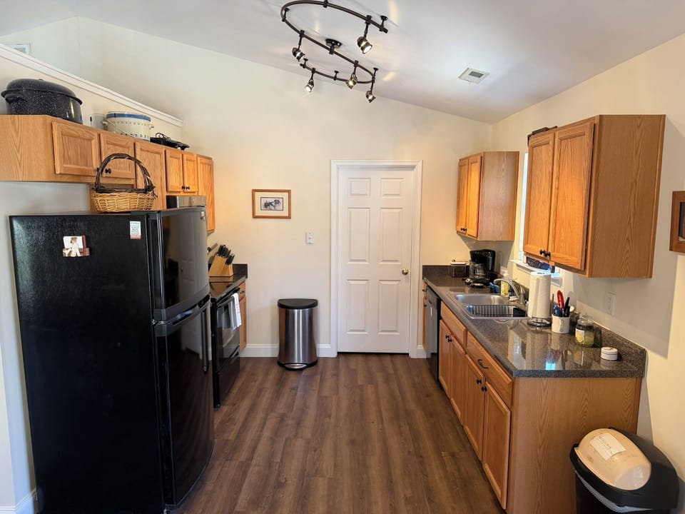 View of the kitchen from the dining area facing door to the laundry room/pantry.