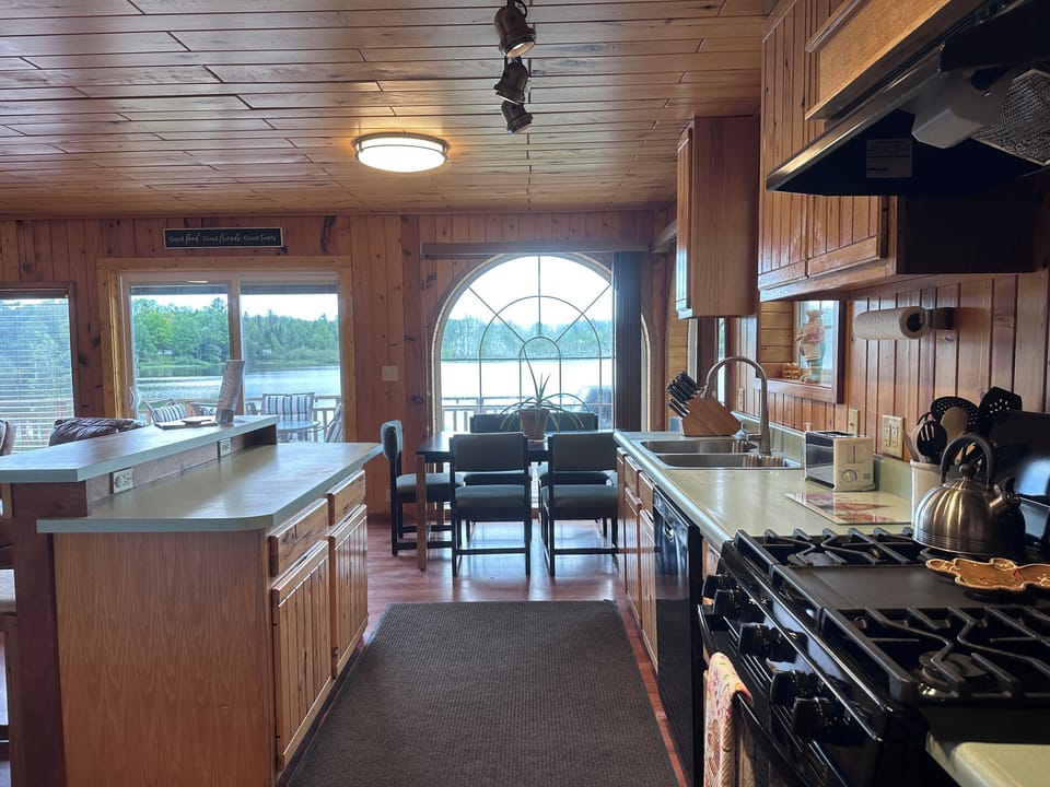Open kitchen featuring tongue and groove hickory cabinets, snack bar, gas stove, refrigerator and freezer with ice maker