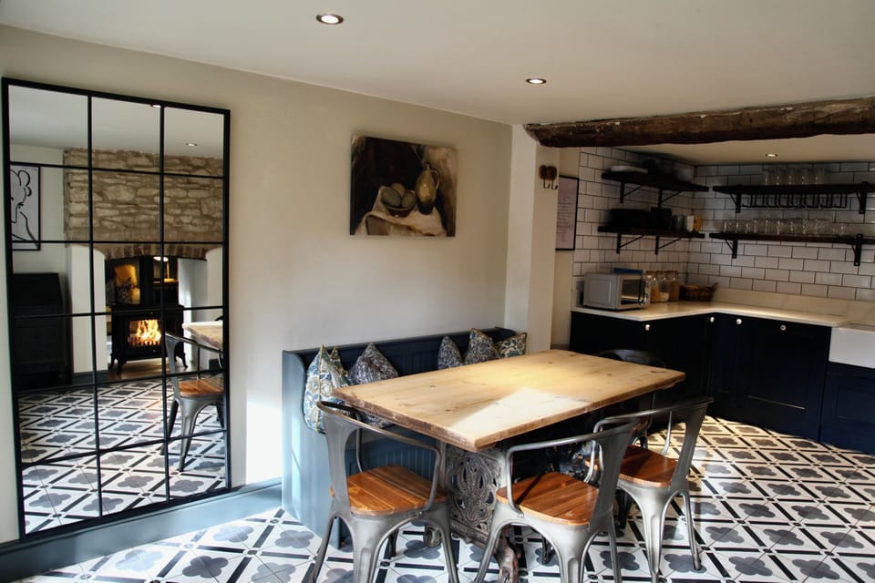 Rustic-modern dining space with designer tiles, open kitchen, and cozy charm