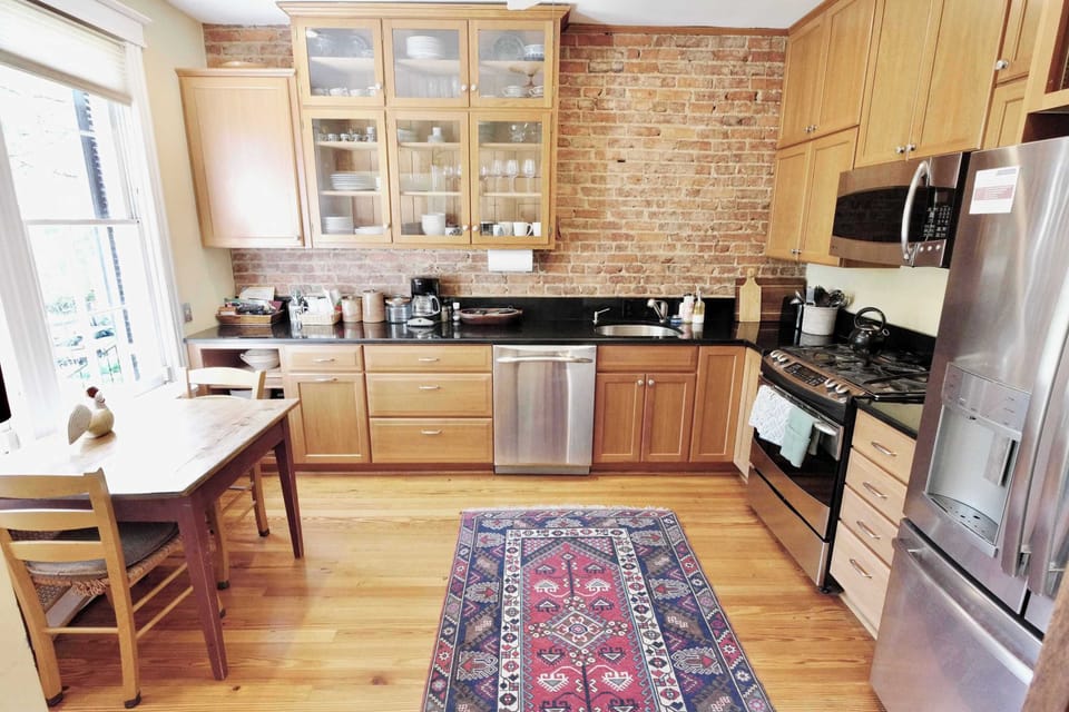 Blending modern convenience with timeless character, this kitchen features exposed brick walls and warm hardwood floors.