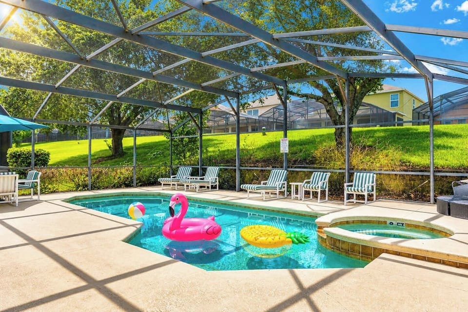 Screened-in pool w/ colorful floaties, perfect for a sunny day with the whole crew.