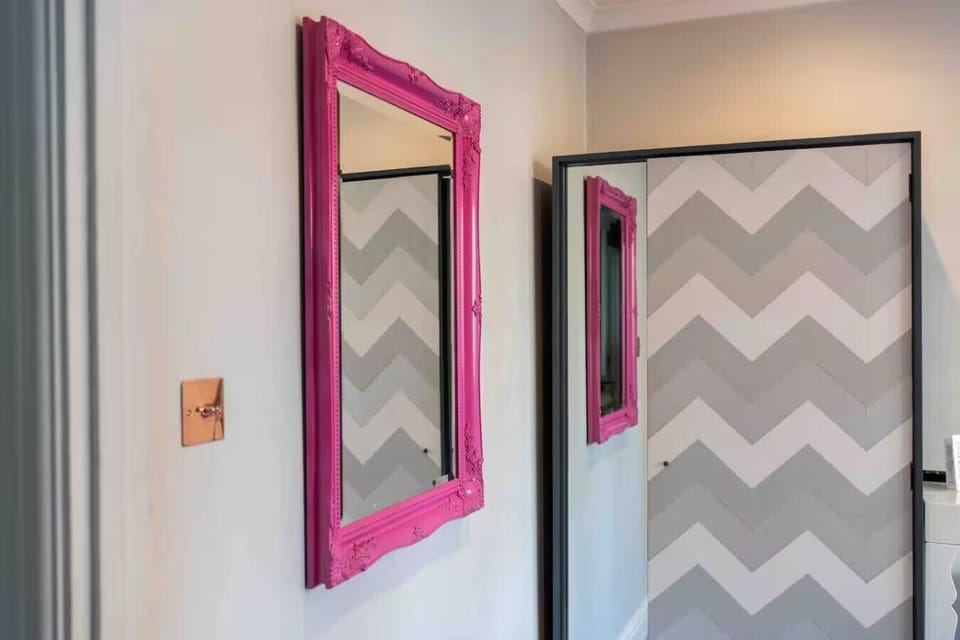 Bold mirror detail adds a fun pop of color to the bedroom