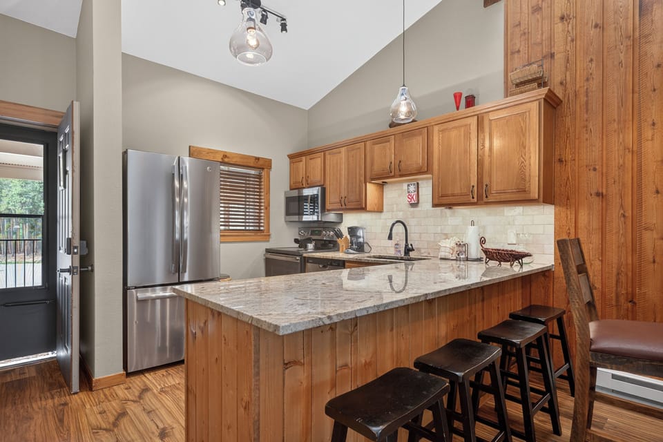 Your fully equipped kitchen features modern appliances, granite countertops, and a spacious island with seating—perfect for preparing meals and gathering with loved ones.