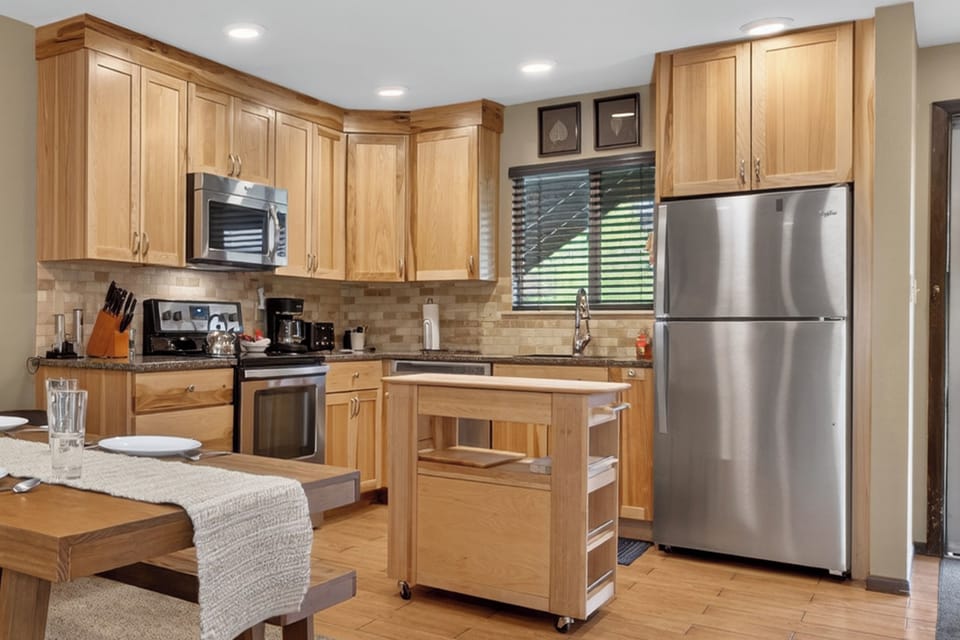 Your fully-equipped kitchen awaits with warm wood cabinetry, stainless steel appliances, and everything you need to cook and gather comfortably during your stay.