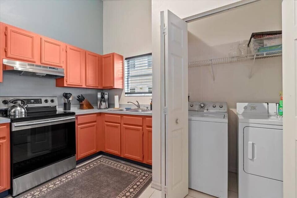 Next to the kitchen is a laundry closet with a washer & dryer.
