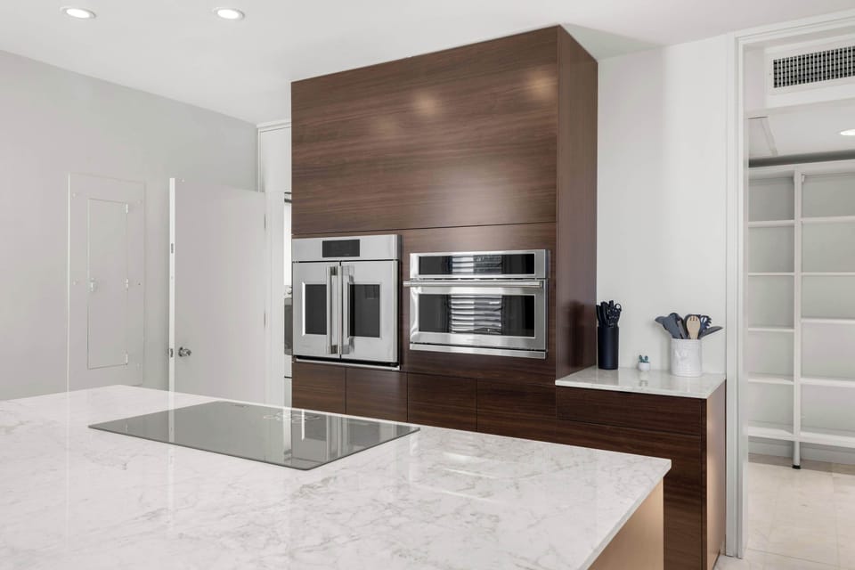 Premium appliances, including a built-in wall oven, complement this stylish kitchen's culinary capabilities and sophisticated finishes.