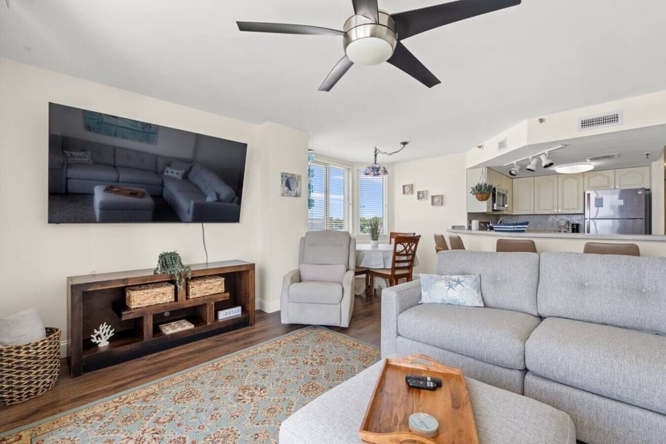 Large open floor plan at The Pinnacle North Myrtle Beach Unit 506 features cozy wraparound couch seating, recliner, and a spacious layout perfect for relaxing by the ocean.