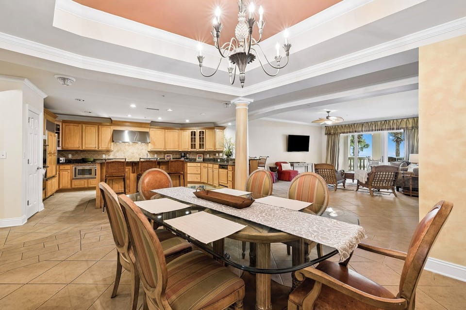 A spacious open layout where your gourmet kitchen flows into your elegant dining and living areas, perfect for gathering with loved ones under a stunning chandelier.