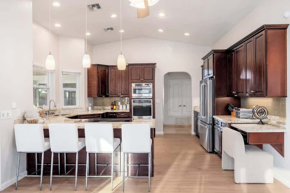 Your gourmet kitchen awaits with rich cabinetry, gleaming granite countertops, and modern appliances. The spacious island with seating invites you to gather, cook, and create lasting memories in this beautifully appointed space.