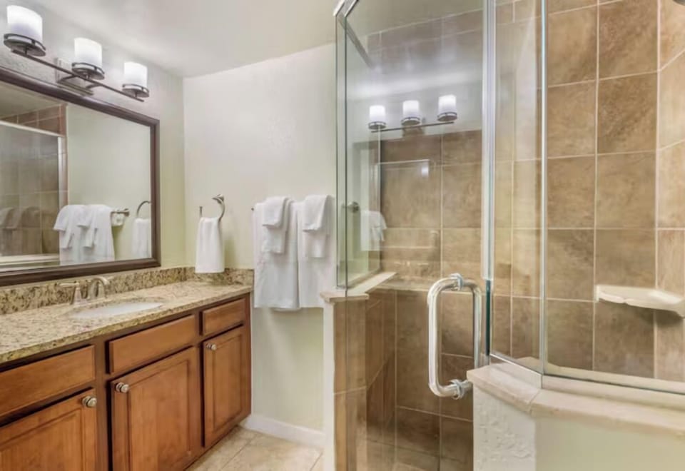 Refresh in a spotless bath with glass shower and vanity.