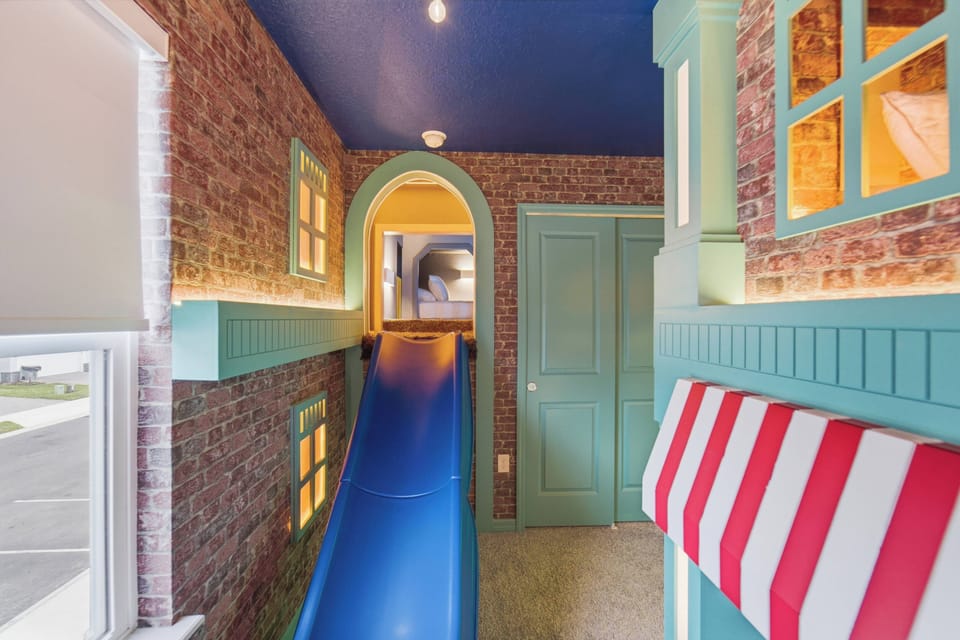 Rest in a playful themed bedroom with a cozy bunk bed, brick-style walls, striped awning, warm window lights, soft carpet, and charming dining-inspired decor, creating a fun space for kids during vacation.