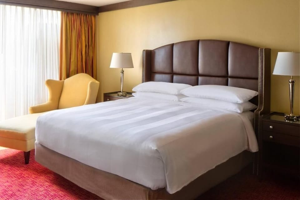 Sink into a plush king bed beside soft, glowing lamps.