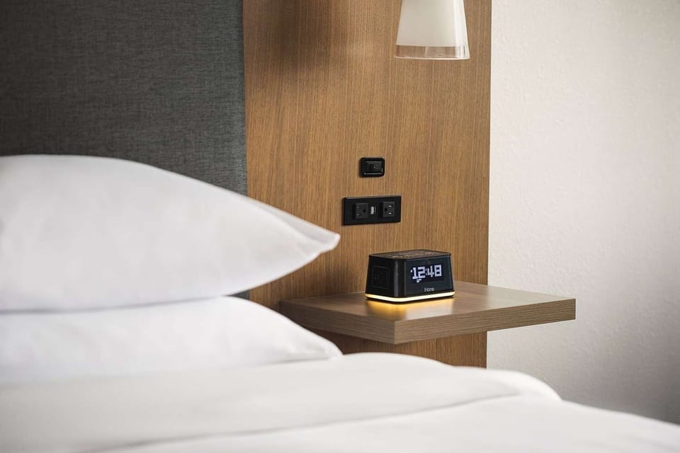 Unwind bedside with warm lighting and easy-charging outlets.