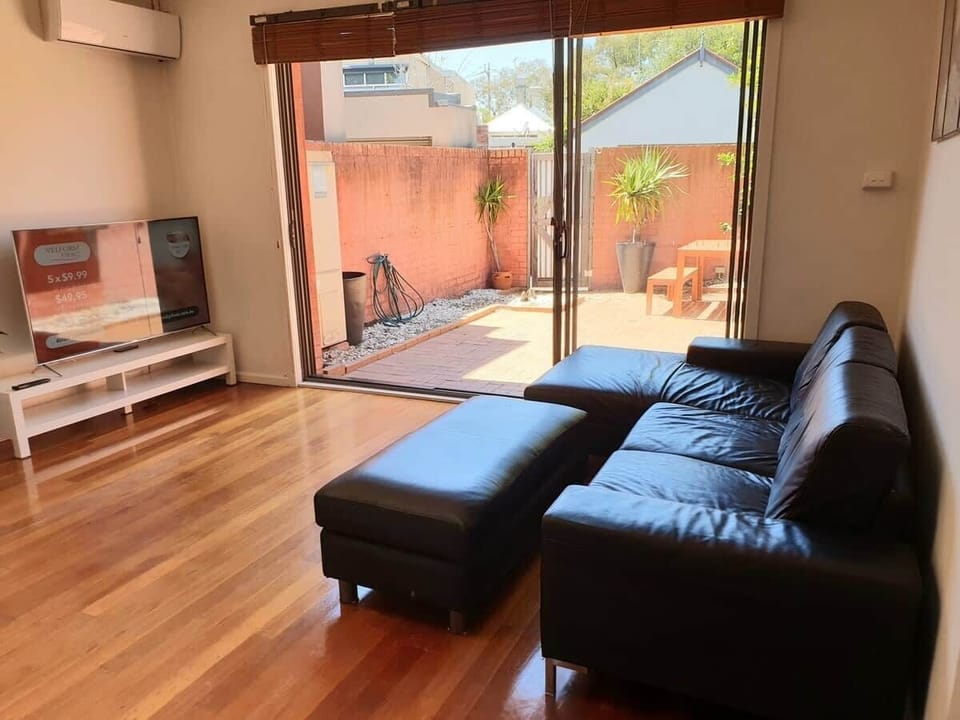 Three seater leather couch with chaise and ottoman overlooking the courtyard.