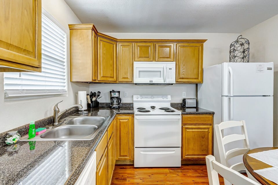 Bright eat-in kitchen with full appliances and warm wood cabinetry