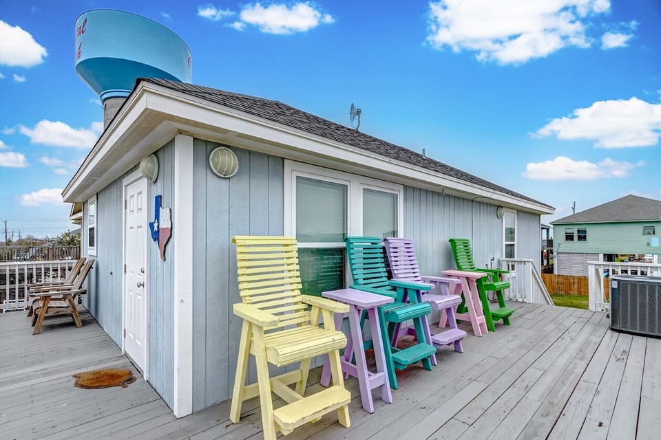 Colorful rooftop deck with lounge seating, open skies, and beach-house charm