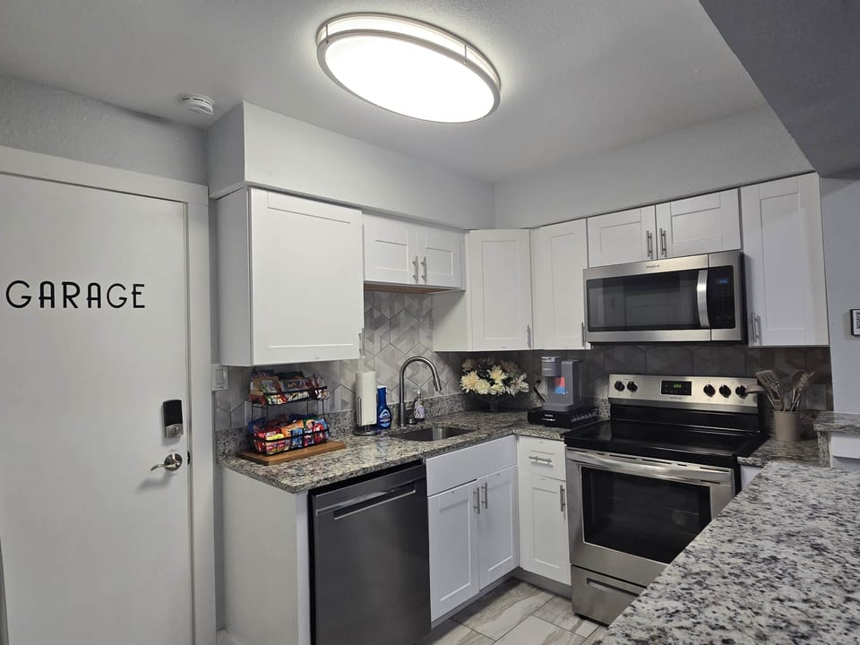 Fully stocked kitchen with cookware, dishes, utensils, glassware, and baking essentials.