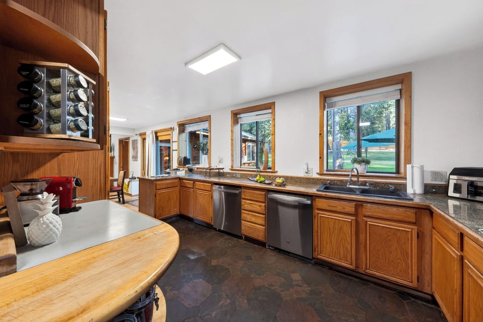 Fully equipped, expansive kitchen featuring long countertops, two dishwashers, and extensive cabinetry.