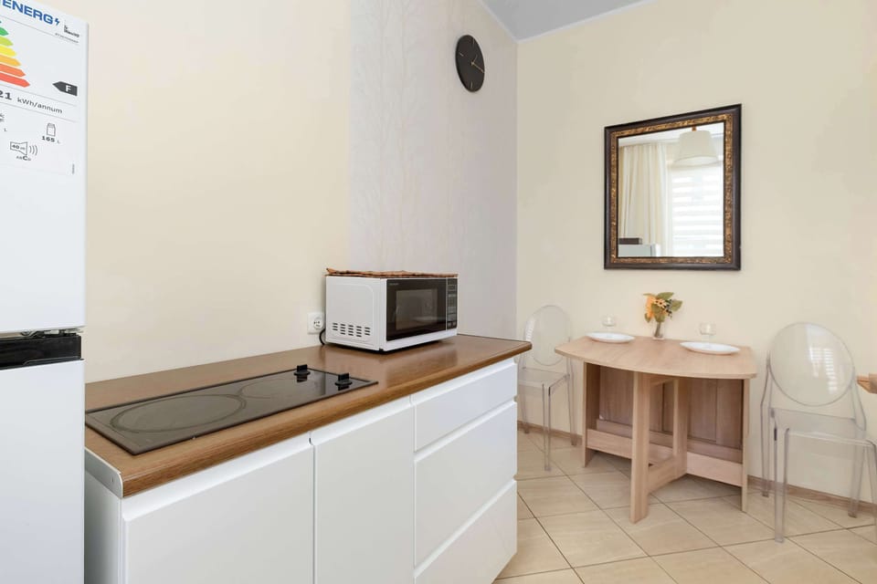 A compact dining and kitchen area with a microwave and a small table. The room features a clean and modern design.