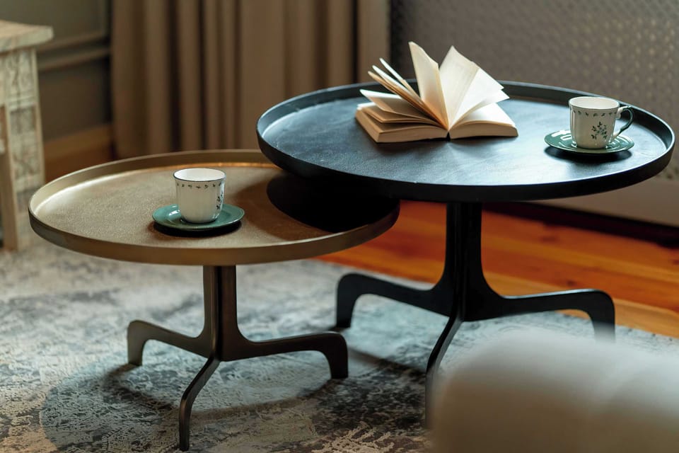 A stylish coffee table with books and a cup placed on top. The seating area feels modern and inviting.