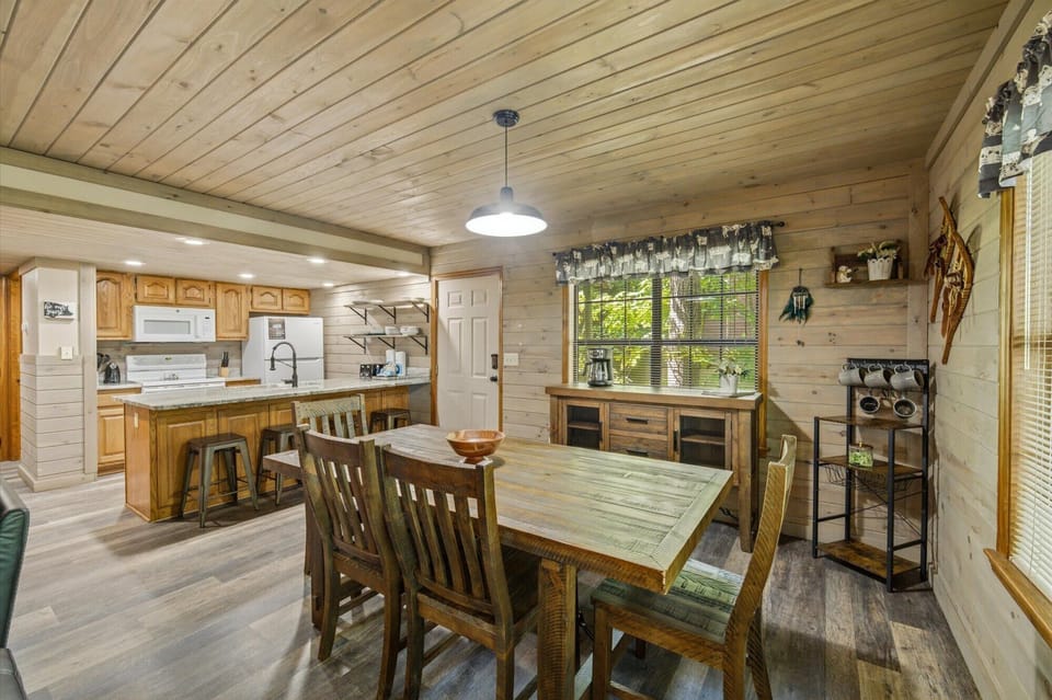 Picture yourself gathering around this handcrafted dining table in your cozy cabin retreat. Natural wood surrounds you, with a fully-equipped kitchen ready for home-cooked meals and a sunlit window framing peaceful forest views.