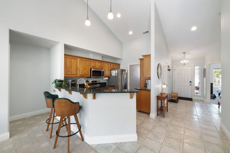 Bright, open living space with a welcoming breakfast bar and well-equipped kitchen—perfect for preparing your favorite meals and enjoying morning coffee while soaking in the modern comforts of your home away from home.