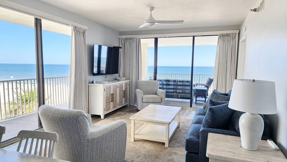 Bright beachfront living room with private balcony and sweeping ocean views