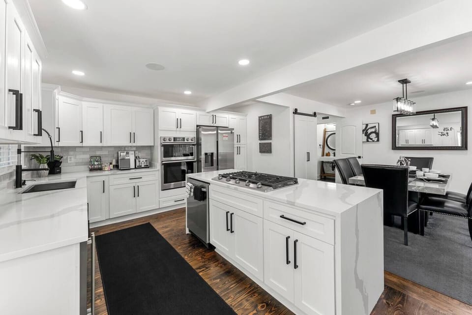 Spacious, fully equipped kitchen with open layout that flows into a stylish dining area, perfect for cooking and enjoying meals. Ideal for business travelers or vacationers seeking comfort.