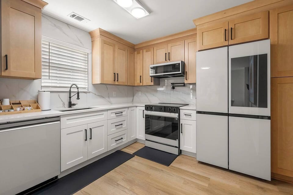 Chef-inspired kitchen with custom cabinetry, quartz countertops, and high-end Samsung appliances including a smart fridge and glass cooktop. Fully stocked for your stay, this space blends luxury and function with style to match.