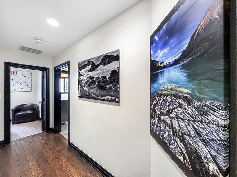 Just beyond the master suite, a warm hallway leads to the guest bedroom, thoughtfully separated for privacy, yet connected by the same cozy chalet charm
