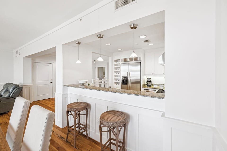 Bright, open kitchen with granite counters and breakfast bar seating invites you to prepare meals and gather with friends over morning coffee.