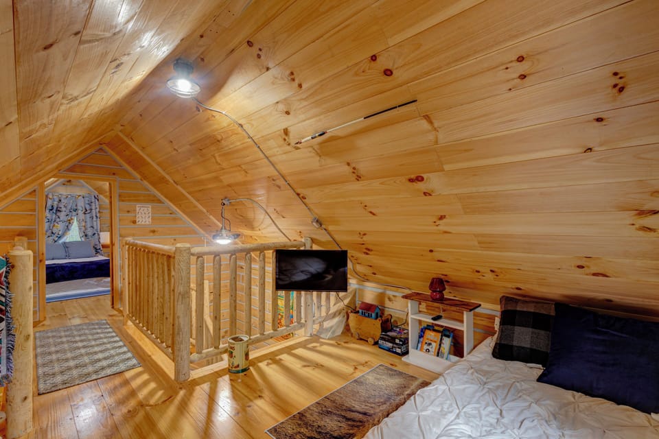 Cozy wood-paneled loft with extra sleeping space and cabin charm