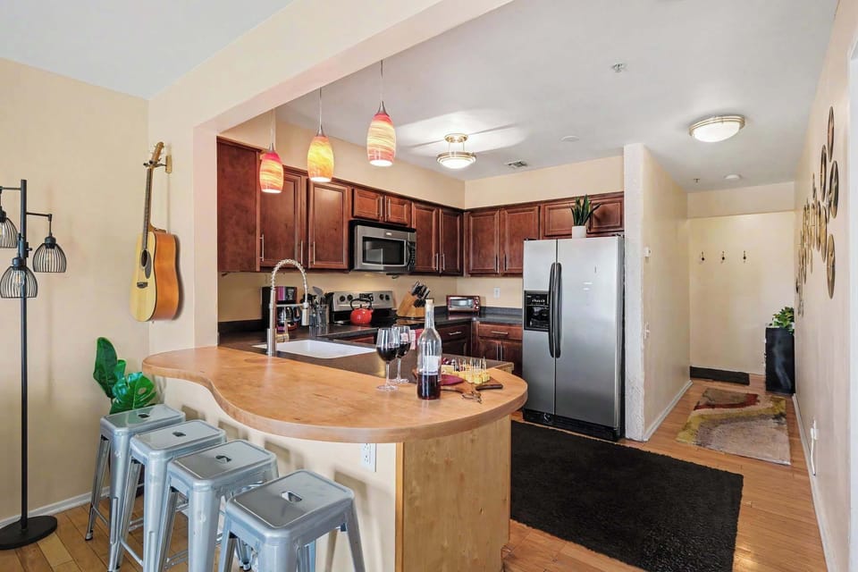 Spacious kitchen with stainless steel appliances, generous counter space, and a breakfast bar with seating for four.