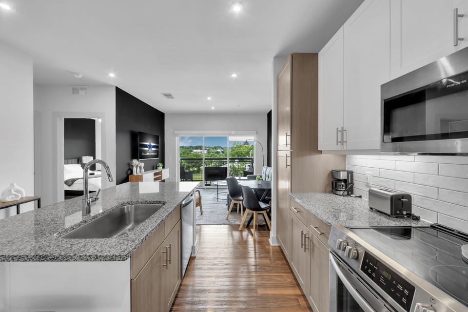 Bright modern kitchen with open living space and scenic balcony view