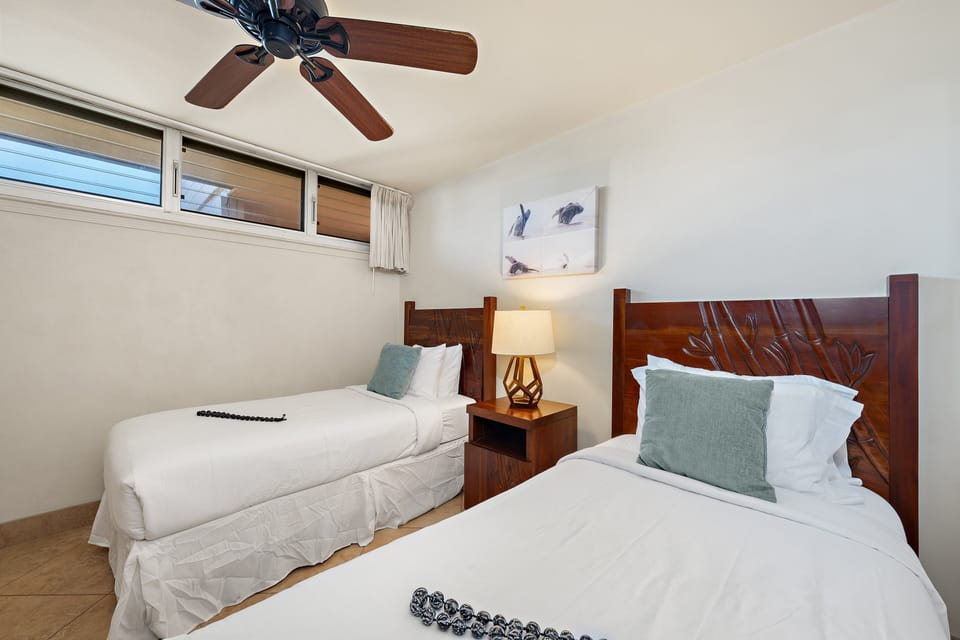 Comfortable second bedroom with two twin beds, ceiling fan, and flexible layout for guests.