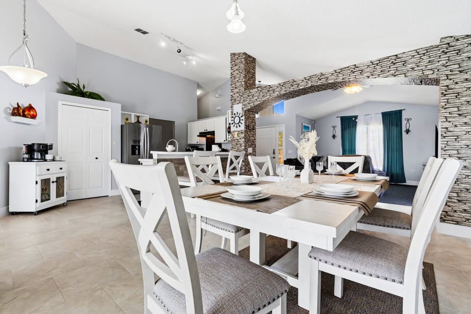 Gather around the spacious dining table with seating for the whole group, perfectly positioned within the home's bright and open-concept layout.